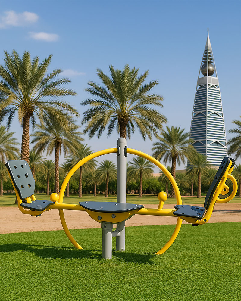 Dennis Inclusive Seesaw in Yellow, against a hot climate cityscape with sand as surfacing.